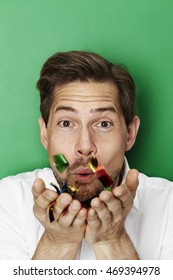 Man Blowing Confetti In Green Studio