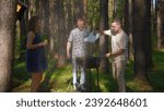 Man blows up coals on grill. Stock footage. Friends are standing at grill and blowing up coals in forest. Friends cook on grill and blow up coals for roasting meat outdoors in summer