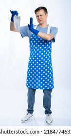 Man In Blue Apron, Rubber Gloves, Blue T-shirt, Jeans. The Homeowner Is Holding A Dirty Sock. White Background.