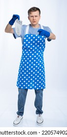 Man In Blue Apron, Rubber Gloves, Blue T-shirt, Jeans. The Homeowner Is Holding A Dirty Sock. White Background.