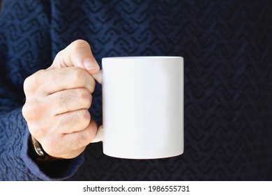 Man In Blue And Black Sweater Holding White Coffee Mug , White Porcelain 11 Oz Mug Mock Up