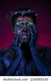 Man With Blue Body Paint And Apple On Red Background