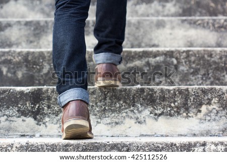 man with blue geans and  sneaker shoes in stair