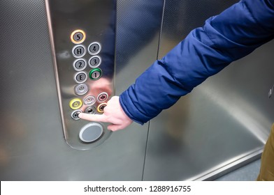 Man In A Blue Jacket In The Elevator Presses His Finger On The Button To Close The Door