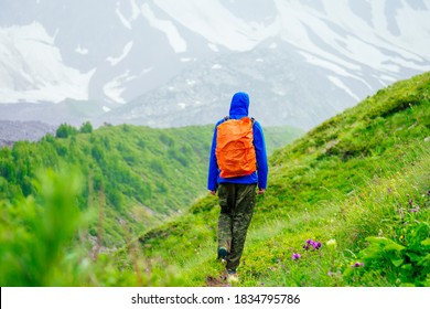 Man In Blue Jacket With Rain In Mountains