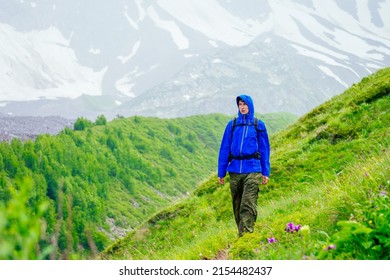 Man In Blue Jacket With Rain In Mountains