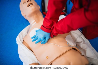 A Man With Blue Rubber Gloves Gives Artificial Respiration To The Doll And Resuscitates The Heart. Exercise First Aid