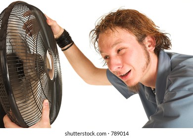 Man With Blue Shirt Cooling Down In Front Of A Fan.