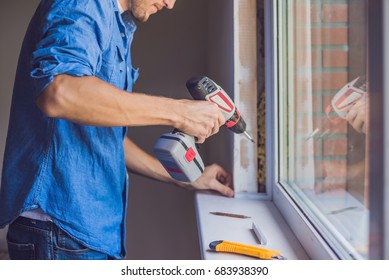 Man In A Blue Shirt Does Window Installation.