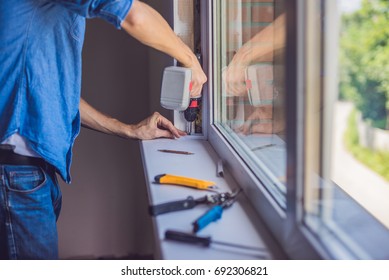 Man In A Blue Shirt Does Window Installation.