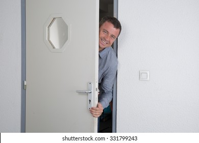 Man With A Blue Shirt Opening A Door