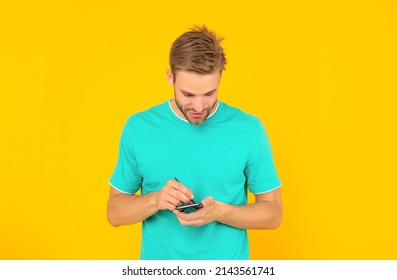 Man In Blue Shirt Use Stylus And Cellphone On Yellow Background, Technology