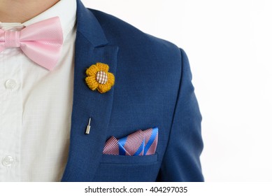 Man In Blue Suit With Pink Bow Tie, Flower Brooch, And Pink Blue Strip Pocket Square, Close Up