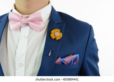 Man In Blue Suit With Pink Bow Tie, Flower Brooch, And Pink Blue Strip Pocket Square, Close Up