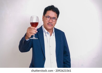 Man In Blue Suit Raising Glass Of Red Wine