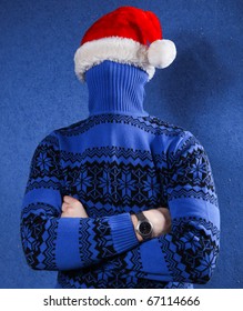 Man In Blue Sweater And Red Chrismas Hat At Blue Background