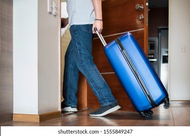 Man With Blue Trolley Luggage Leavin The House