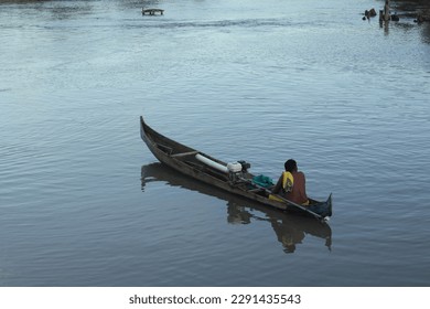 A man in a boat is rowing a boat with a yellow shirt on it - Powered by Shutterstock