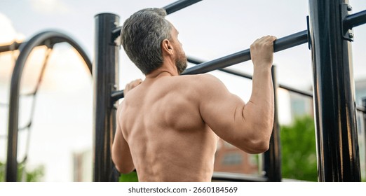 Man bodybuilder do pullup exercise. Muscular biceps and triceps. Strong athlete. Man pullup at outdoor gym. Muscular man with strong back muscle. Gym bar. Sport pullup workout. Sport training