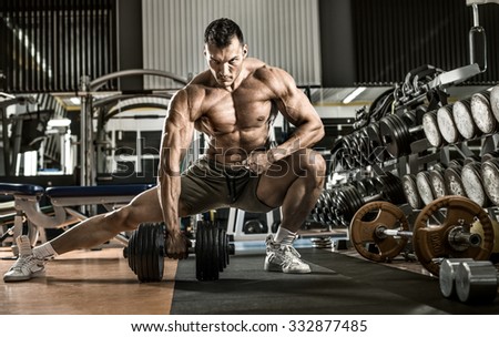man bodybuilder , execute exercise with  dumbbells, inside gym, horizontal photo