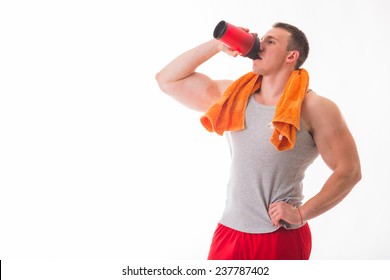 Man Bodybuilder Posing On White Background Man Is Holding A Shaker For Drinks. Man Drinking A Protein Shake, Water, Amino Acids From The Shaker. Sports, Sports Nutrition, Food Additive.