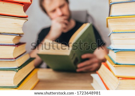 A man with a book between stacks of books - passionate about the novel - classic literature