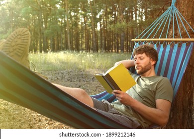 Man with book resting in comfortable hammock outdoors - Powered by Shutterstock