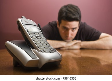 A man is bored waiting for the phone to ring