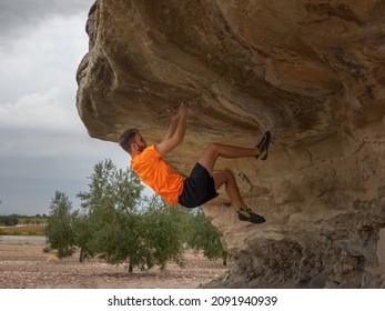 Man Bouldering Outside In A Cave