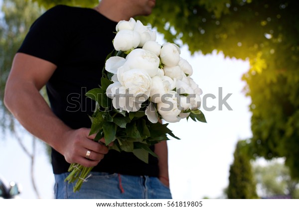 Man with bouquet of\
nice white flowers.