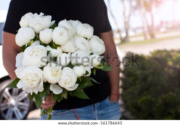 Man with bouquet of
nice white peonys.