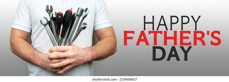 Man with bouquet of wrenches, spanners and screwdrivers banner with inscription happy father's day. Panoramic web header. Happy fathers day concept or greeting card