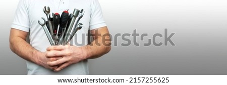 Man with bouquet of wrenches, spanners and screwdrivers banner. Panoramic web header with copy space. Wide screen wallpaper
