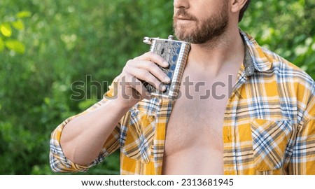 man with bourbon hipflask, copy space. man with bourbon hipflask outdoor.