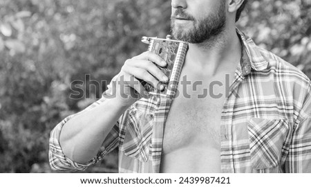 man with bourbon hipflask, copy space. man with bourbon hipflask outdoor.
