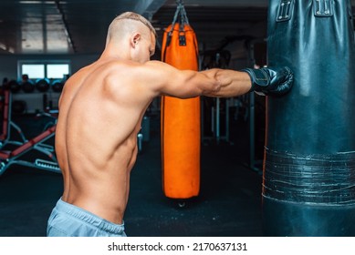 Man Boxer Arms At Workout. Young Male Is Boxing Punching Bag.Man Exercise Athletic Boxing Concept.Side View,close Up.