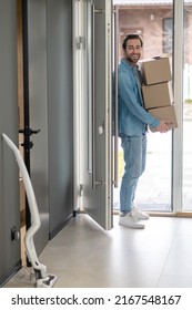 Man With Boxes In Hands Entering House