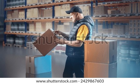 Man with boxes inside warehouse. Warehouseman distributes parcels to storage locations. Warehouse manager near multi-tiered racks. Man works as loader in storage. Courier company warehouse
