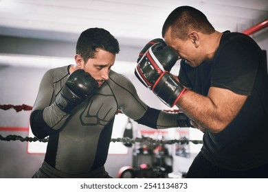 Man, boxing coach and training in gym with punch for challenge, fitness and exercise for competition. People, boxer and gloves for workout in ring for martial arts, fight and strong for contact sport - Powered by Shutterstock