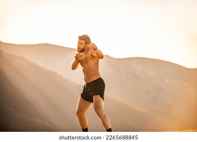 Man boxing with shadow exercising at sunset outdoor. Port victory healthy lifestyle concept. Man shadow boxing little champion boxer silhouette sun - Powered by Shutterstock