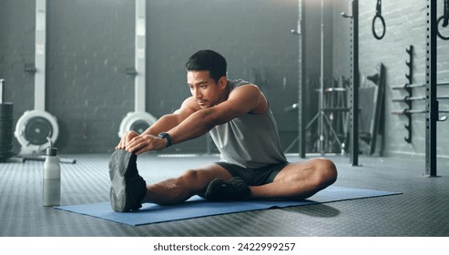 Man, break and stretching on gym floor in fitness, workout or training for strong muscles, heart health or cardio wellness. Japanese personal trainer, sports person or coach in body warmup exercise - Powered by Shutterstock