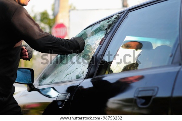 man breaking car\
window