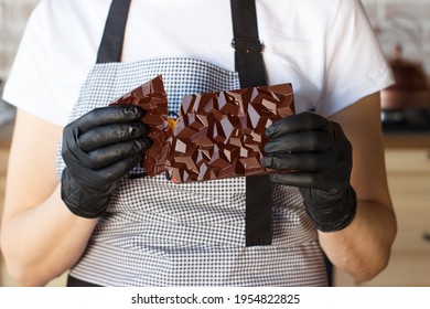 Man breaking chocolate. Stock footage. Close-up of hands breaking chocolate bar into two parts. Delicious chocolate is broken into pieces