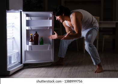 Man Breaking Diet At Night Near Fridge