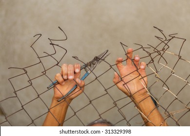 A Man Breaking Down The Fence. Immigration Concept