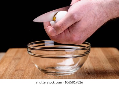 A Man Is Breaking An Egg. Yolk From A Broken Shell.