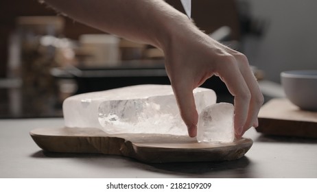 Man Breaking Ice Block With Knife On Olive Wood Board