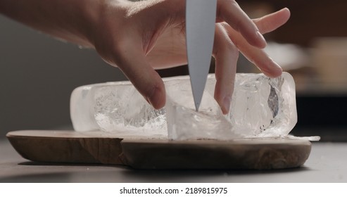 Man Breaking Ice Block On Olive Wood Board, Wide Photo