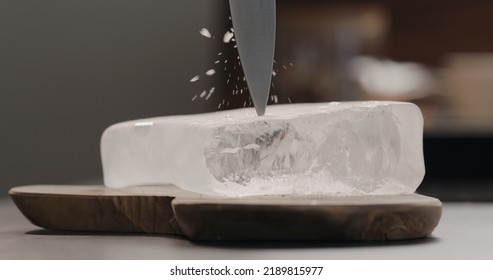 Man Breaking Ice Block On Olive Wood Board, Wide Photo