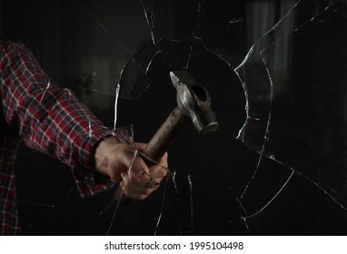 Man Breaking Window With Hammer On Black Background, Closeup